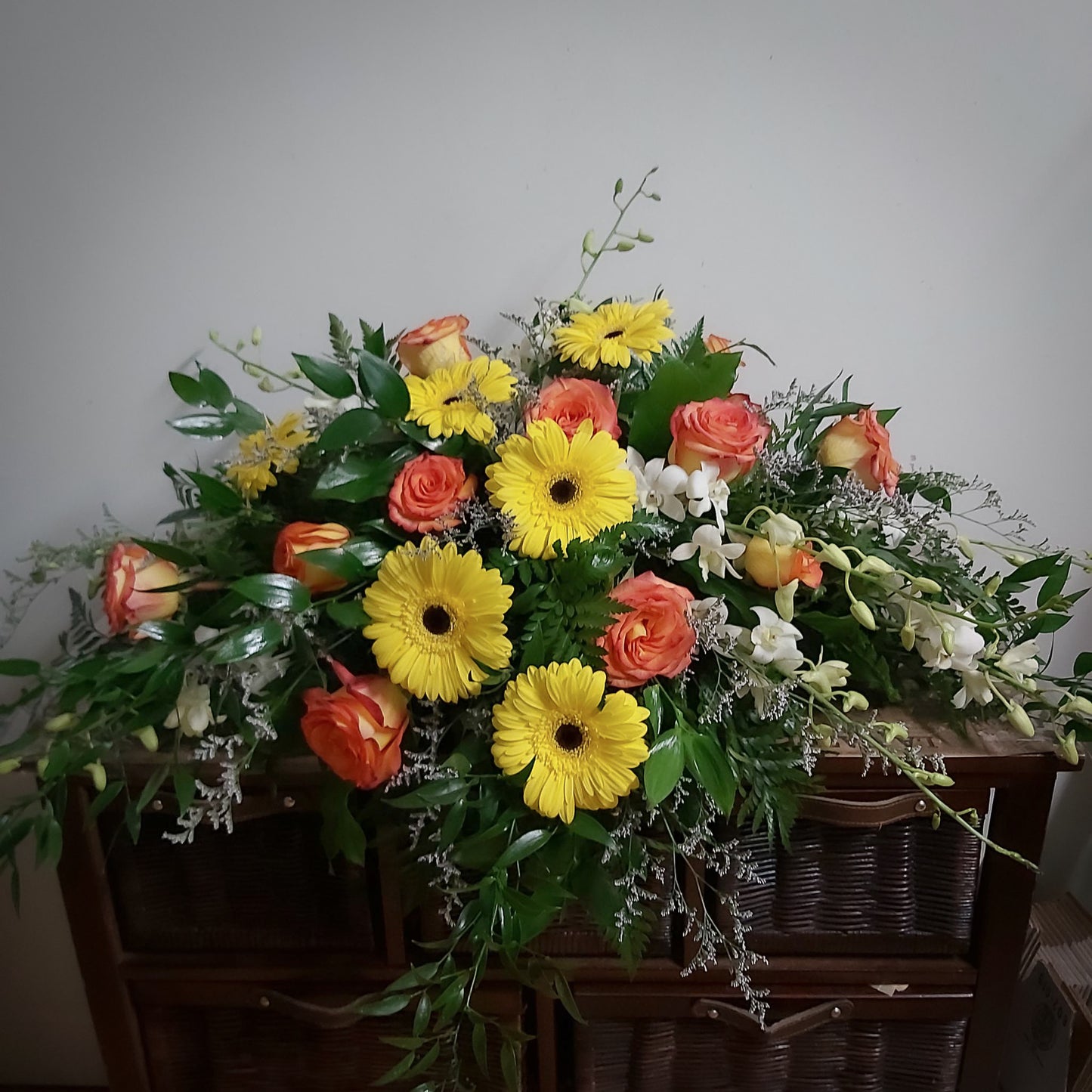 coussin coloré composé de gerbera jaune, rose orangé, dendrobium blanc et delphinium mauve . Nous pouvons également changé les couleurs de les fleurs à votre image.